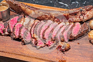 Dry-aged marble beef steak Tomahawk on wooden board with spices. Close-up, dinner concept