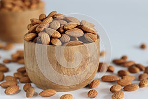 Dry Almonds in wooden bowl. Abundant pile of pealed dry almonds