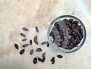 Dry barberries in a bowl on grey concrete table top