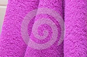 Dry bath towels are purple in the bathroom