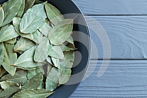 Dry bay leaf or laurel in bowl on wooden table