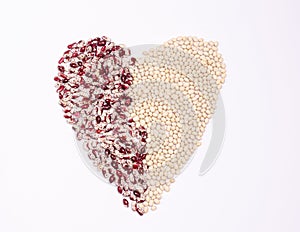 Dry beans of two varieties for vegans in the form of a heart on a white background