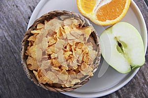 Dry Breakfast muesli on a plate and fruit Apple and orange