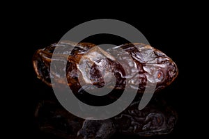 Dry brown date fruit isolated on black glass