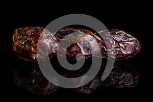 Dry brown date fruit isolated on black glass