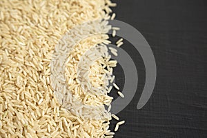 Dry Brown Rice background, side view. Copy space