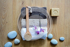 Brush, towels, orchids and eco-friendly soap over zen stones