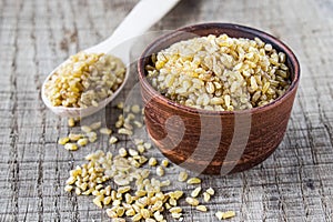 Dry bulgur grain in a bowl. Healthy, dietary, vegan, gluten free product. Organic product made from wheat grains