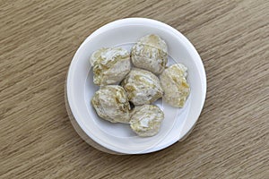 Dry candlenut in white bowl on wooden table