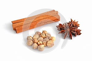 Dry cardamom, Anise stars, and cinnamon sticks on a white background. Selective focus