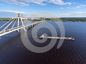 The dry cargo ship barge passes along the Sheksna River after the October cable-stayed bridge. Cherepovets, Vologda region, Russia