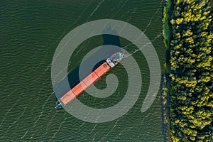 Dry cargo ship with a bird`s eye view on the background of the green color of the river