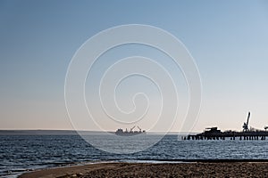 A dry cargo ship with open bilges is anchored in the middle of a wide river. A five-cargo ship in the outer waters of the Nikolaev