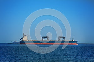 Dry cargo ship in the open sea with many containers