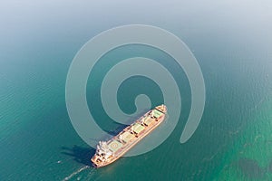 The dry cargo vessel enters the port with the help of tugs. Photo from a helicopter. Bird's-eye view.