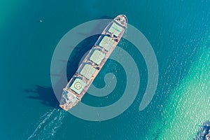 The dry cargo vessel enters the port with the help of tugs. Photo from a helicopter. Bird's-eye view.