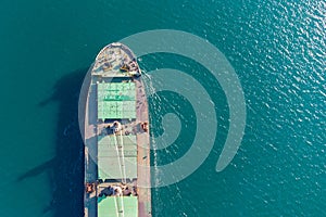 The dry cargo vessel enters the port with the help of tugs. Photo from a helicopter. Bird's-eye view.