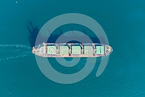 The dry cargo vessel enters the port with the help of tugs. Photo from a helicopter. Bird's-eye view.