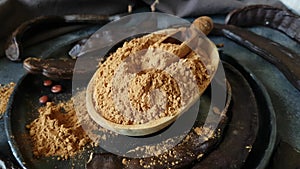 Dry carob pods and powder close up