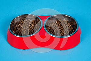 Dry cat food in bowls isolated on blue