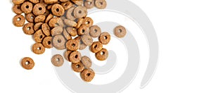 Dry cat food ringlets scattered on a white background.