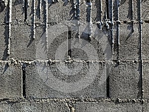 Dry cement drips on bricks wall. Mortar dripping and running down the finished brick wall. Surface and textured of cement wall.