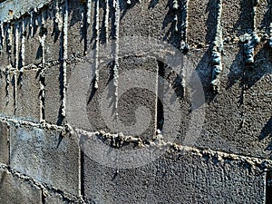 Dry cement drips on bricks wall. Mortar dripping and running down the finished brick wall. Surface and textured of cement wall.