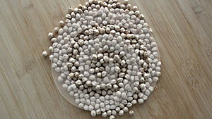 Dry chickpeas or dried garbanzo beans rotating background top view. Ingredient for falafel. Cicer arietinum.