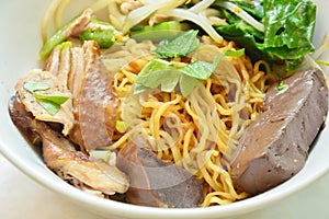 Dry Chinese egg noodle with duck meat and bean sprout on bowl