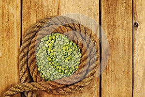 Dry chopped peas. Green beans. Ship rope. Rough boards. Wooden background. Healthy food. View from above