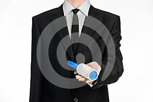 Dry cleaning and business theme: a man in a black suit holding a blue sticky brush for cleaning clothes and furniture from dust is