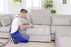 Dry cleaning worker removing dirt from sofa