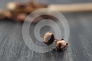 Dry cloves in wooden scoop isolated on white background with clipping path. Top view. Flat lay. selective focus