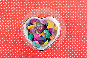 Dry colorful play dough in heart shaped bowl