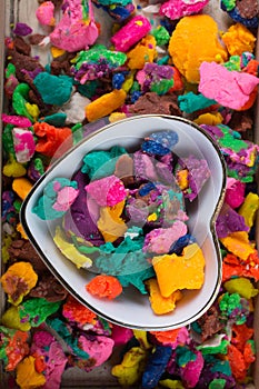 Dry colorful play dough in heart shaped bowl