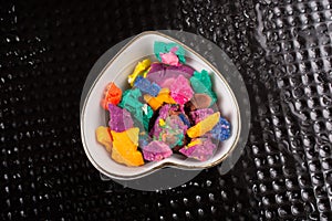Dry colorful play dough in heart shaped bowl