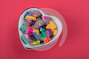 Dry colorful play dough in heart shaped bowl