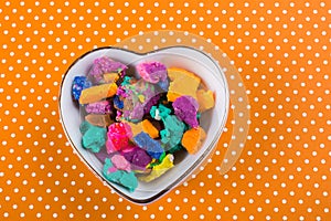 Dry colorful play dough in heart shaped bowl