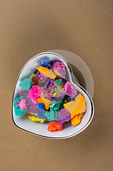 Dry colorful play dough in heart shaped bowl