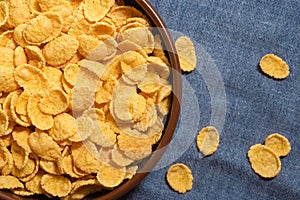 Dry corn flakes in a bowl, close-up. Top view