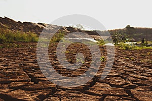 Dry cracked earth background in arid season. Many Province of North East in Thailand the ground dry. Brown cracked soil in the sum