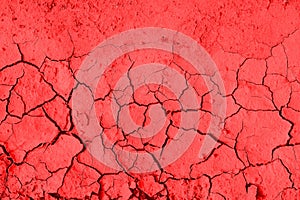 Dry cracked earth background, clay desert texture tinted red.
