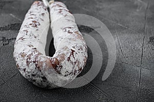 Dry cure salami sausage fuet on grey background with space for text