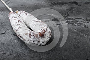 Dry cure salami sausage fuet on grey textured background with copy space