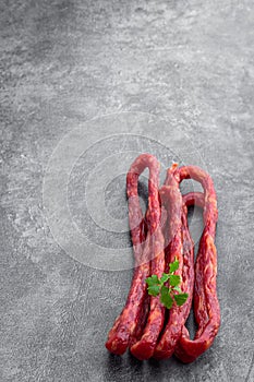 Dry cured Kabanos sausage on gray background