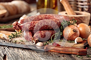 Dry-cured sausage with bread and spices on a old wooden table