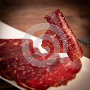 Dry-cured Spanish ham, Serrano ham, Bellota ham, Italian prosciutto crudo or Parma ham, wagyu slice