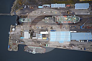 Dry dock and ship with shipbuilding in construction activity aerial view from above Greenock UK