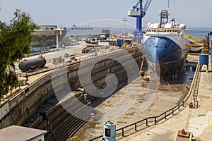 Dry dock of a shipyard in Gibraltar where they are cleaning the hull of a ship dedicated to transporting vehicles