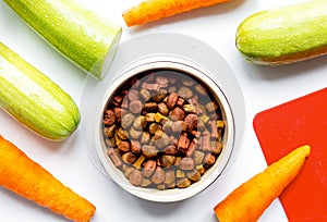 Dry dogfood with carrot and zucchini on table background top vie photo